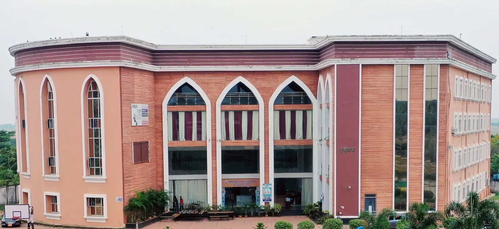 Front of the red-brick main academic block with its arched windows