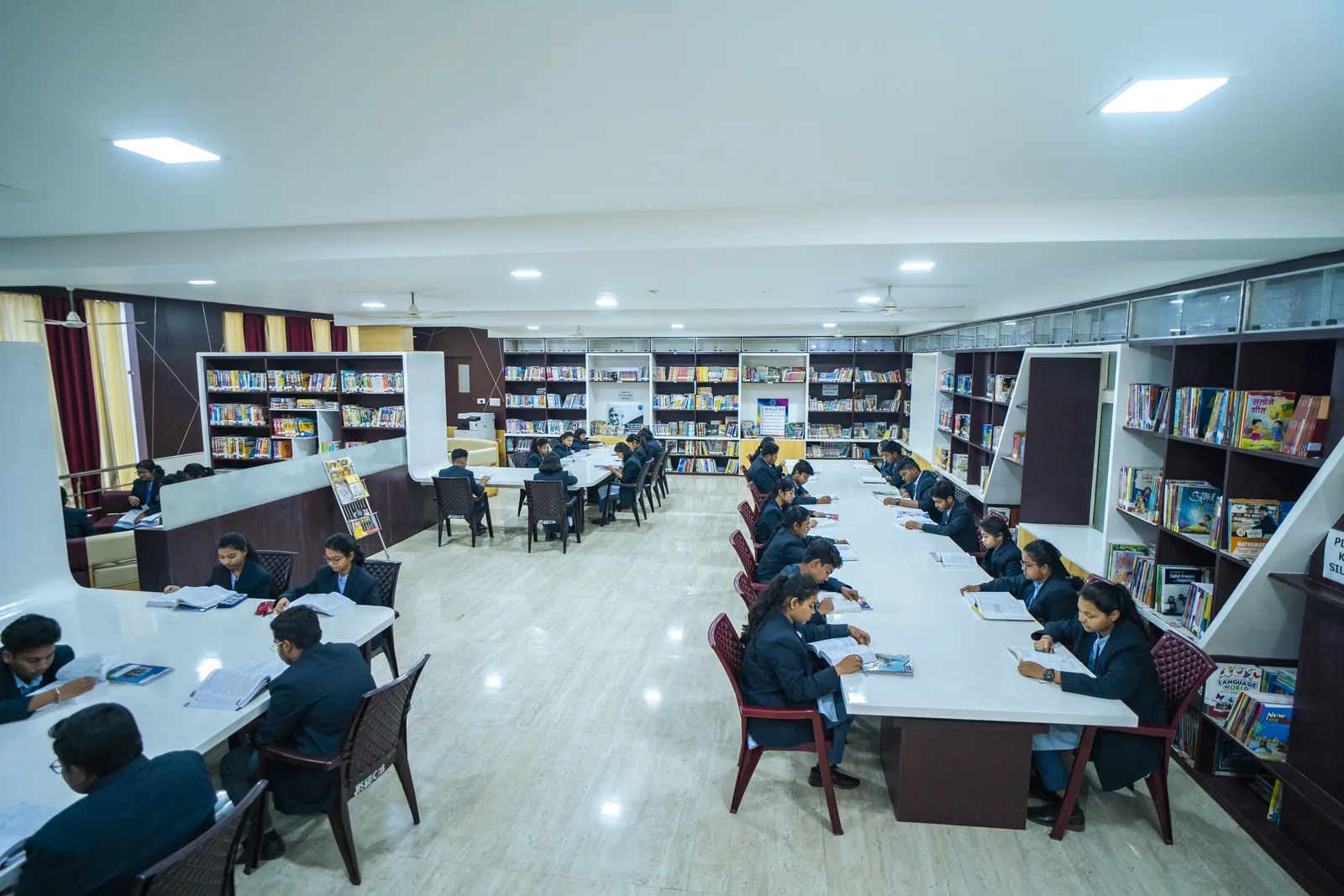 School library with long study tables and reference book shelves.