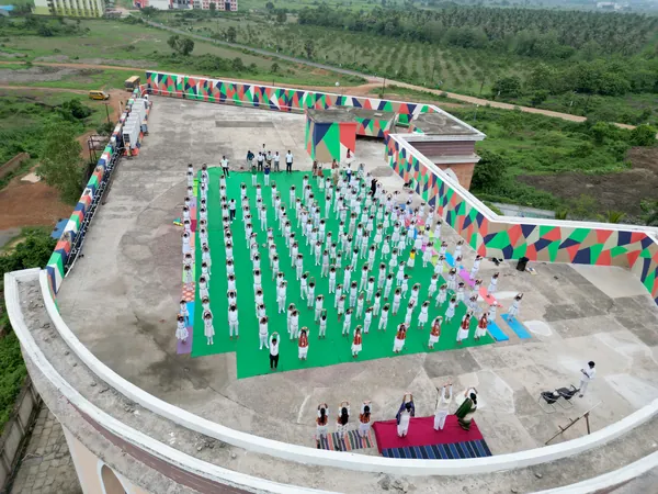 Aerial view of students performing synchronized yoga asanas.