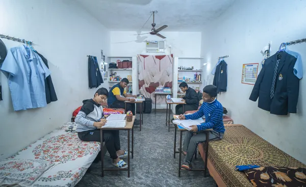 Boarders studying at desks in their hostel room.